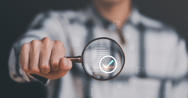 person holds magnifying glass with document icon inside