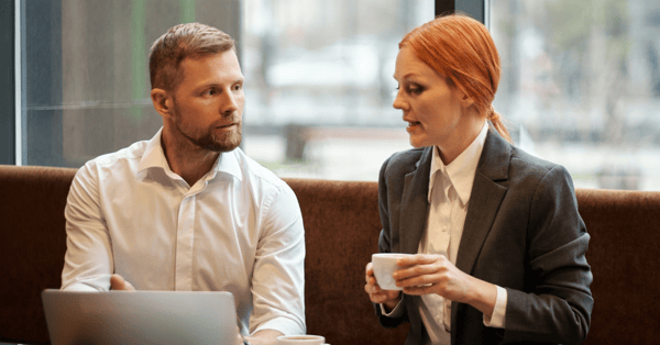 two business people chat over coffee