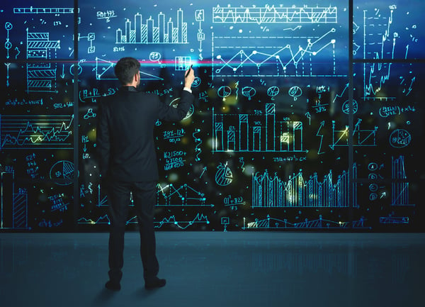 Man calculating on a glass whiteboard 