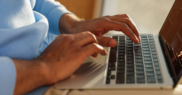 man typing on computer